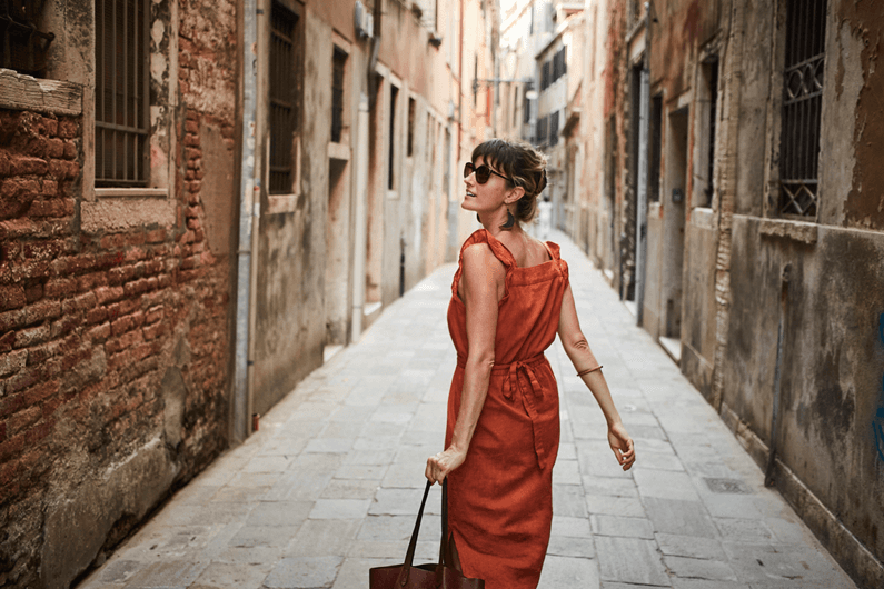 A woman walks down a brick alley to shop using her Fifth Third checking account.