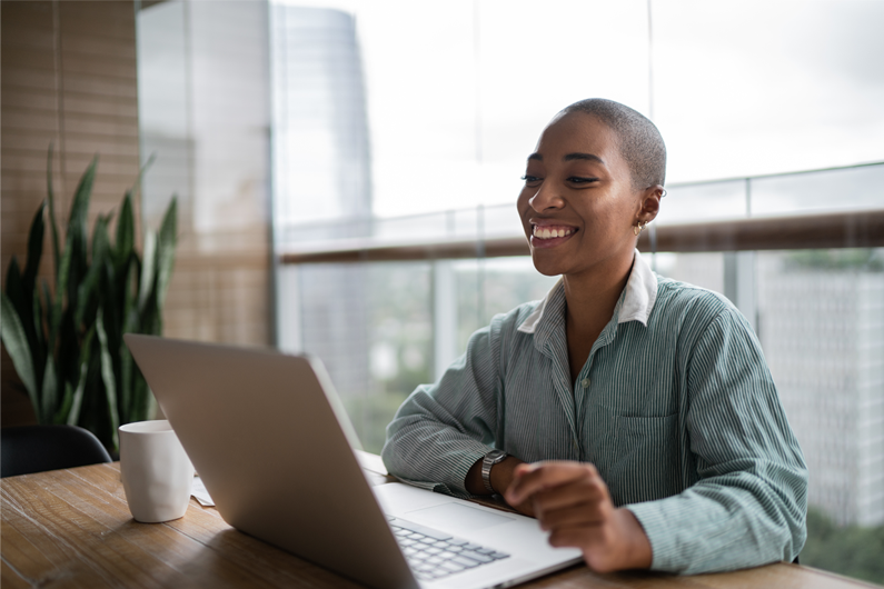 A lady looking at the computer on her desk