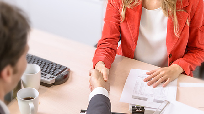 A woman and a man shaking hands.