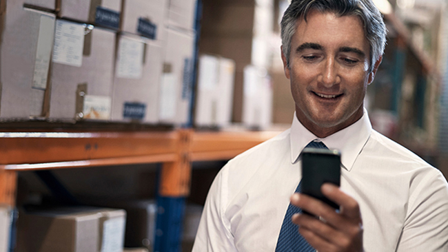 A man holding and looking at his cell phone.