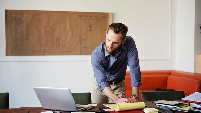 Man reading computer screen working at desk