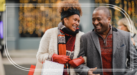 A middle-aged man and woman smiling outdoors